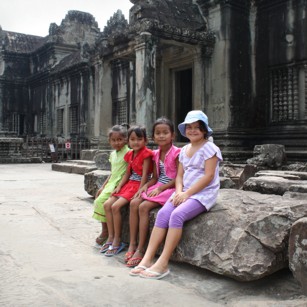 Tourist child sitting among Cambodian girls