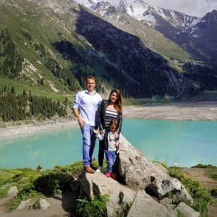 Omnimundi Family standing over a rock in front of Almaty Lake in Kazakhstan