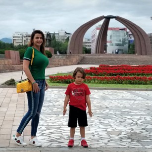 Travelling family posing in a Square in central Bishkek, Kyrgyzstan