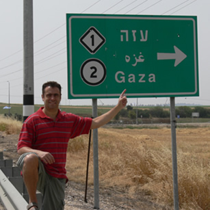 A tourist in front of a road sign in Palestine