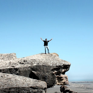 Man stanting on a rock with blue saky in Gobustan, Azerbaijan