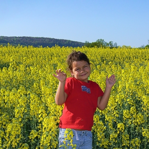 A yellow flower field in Louxembourg with a cute girl