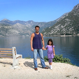 Father and daughter from Omnimundi Family standing at the border of a Fjord in Montenegro
