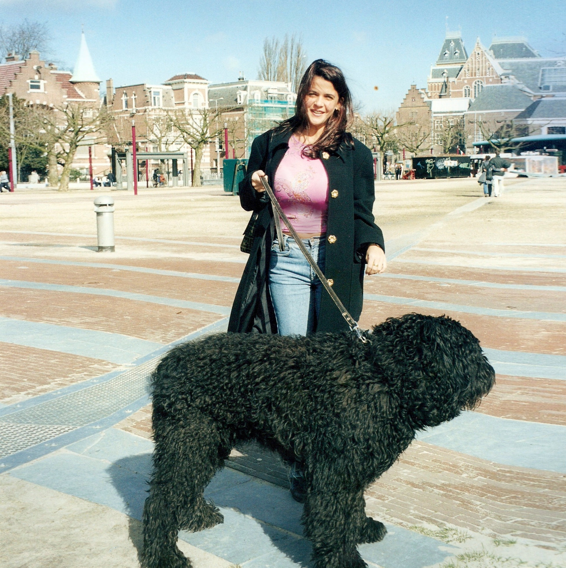 Downtown Amsterdam and a woman holding a big black cute dog