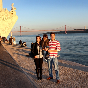 Family of three tourists along the Tejo River in Portugal, by Omnimundi