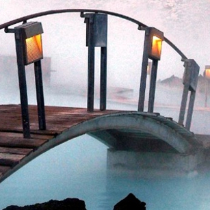 A tiny curved bridge over a blue lagoon in Iceland